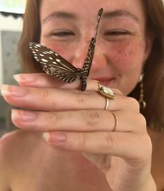 a woman holding a butterfly on her finger