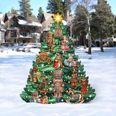 a christmas tree is in the middle of a snow covered yard with houses and trees