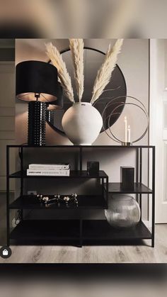 a black shelf with two vases on top of it and a lamp next to it