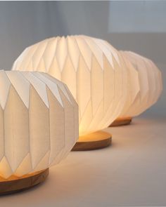 two lamps made out of paper sitting on top of a table next to each other