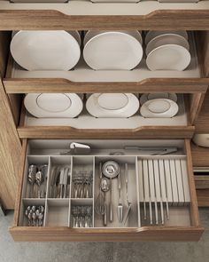 an open drawer with dishes and silverware in it