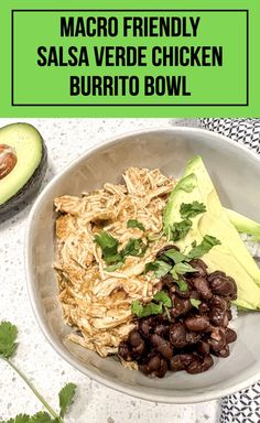 a white bowl filled with beans, avocado and rice next to an avocado