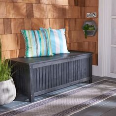 a wooden bench sitting on top of a hard wood floor next to a planter