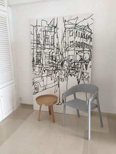 two chairs in front of a painting on the wall and a small stool next to it