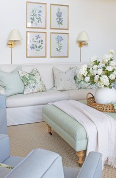 a living room filled with furniture and pictures on the wall above it's coffee table