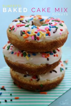 three donuts with white frosting and sprinkles stacked on top of each other