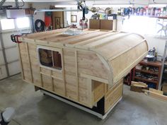 a large wooden boat sitting inside of a garage