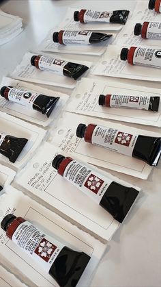 several bottles of red liquid are lined up on white envelopes with black ink in them