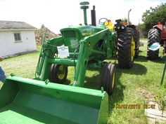 a man standing next to a green tractor