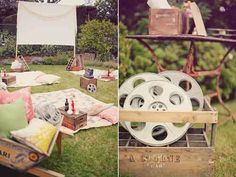 an outdoor movie set up with film reels and other items on the ground, in front of some trees