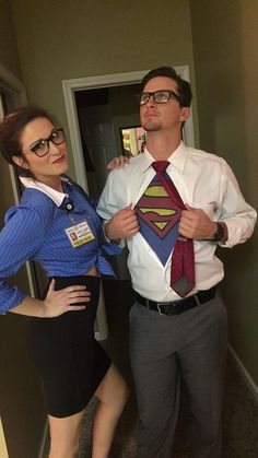 a man standing next to a woman in a dress shirt and tie with a superman costume on