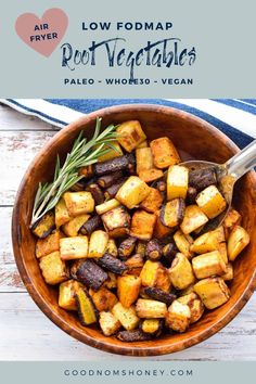 a wooden bowl filled with roasted potatoes and rosemary