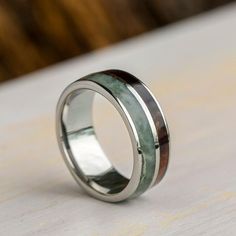 a wedding ring with green wood and silver inlays on the inside of it