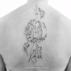 the back of a woman's shoulder with tattoos on her chest and flowers in the center