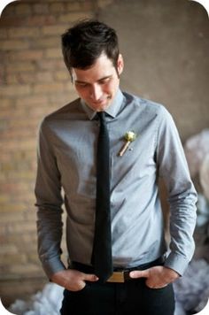 a man wearing a gray shirt and black tie