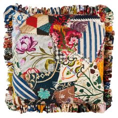 a multicolored patchwork pillow with tassels and flowers on the front