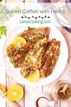 baked fish with herbs and lemons on a white plate