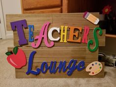 the teacher's lounge sign is made out of wood and painted with colorful letters