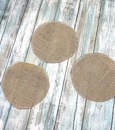 three pieces of burlocked fabric sitting on top of a wooden floor