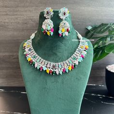 Anvi Multicolor Silver Polki Necklace Set with Maangtikka. Expertly crafted with precision and intricate detailing, the Anvi Multicolor Silver Polki Necklace Set with Maangtikka is a must-have statement piece for any occasion. The stunning multicolor stones and shimmering silver polki add a touch of elegance and sophistication to any outfit. Elevate your style and make a bold statement with this exquisite jewelry set. Traditional Multicolor Kundan Necklace With Stones, Traditional Multicolor Stone Necklace, Festive Multicolor Stone Necklaces, Festive Multicolor Stone Necklace, Multicolor Diwali Jewelry With Stone Setting, Multicolor Stone Setting Jewelry For Diwali, Multicolor Jeweled Bridal Necklace For Wedding, Festive Multicolor Gemstone Necklaces, Festive Multicolor Gemstone Necklace