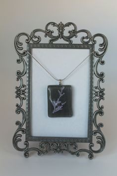 a black and white photo frame with a necklace on it