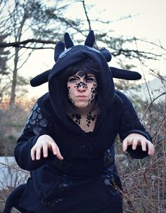 a man dressed as a demon poses for a photo