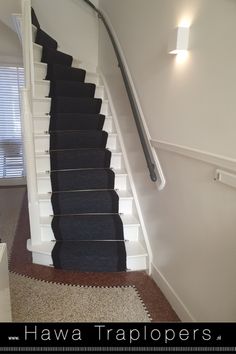 a staircase with black carpet and white railing