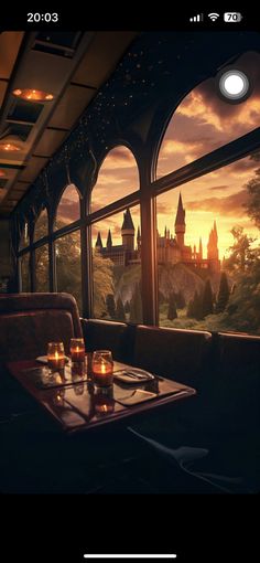 a table with candles on it in front of a window that looks out onto a castle