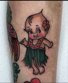 a tattoo on the leg of a person with an image of a baby in a hula skirt