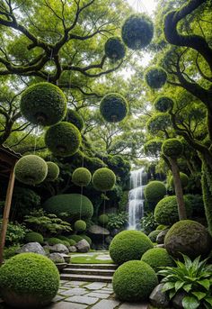 an outdoor garden with stone steps, trees and balls hanging from the ceiling in front of a waterfall