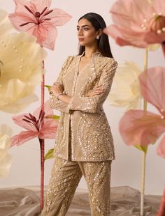 Turn all eyes on you in this primrose hand embroidered pant suit. The bodice is a floral monotone fantasy adorned with floral motif sequins. The combination of fully jacket and pants is an exclusive design and delight to wear. Embrace your inner diva by adding bold statement earrings, and a metallic clutch to own the night! Wedding Outfits For Women, Golden Lace, Gold Jacket, Embroidered Coat, Embroidered Pants, Tulle Lace, Indian Designer Wear, Designer Wear, Wedding Outfit