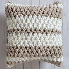 a crocheted pillow sitting on top of a wooden floor