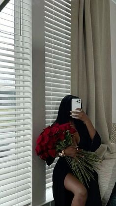 a woman sitting on a couch holding flowers