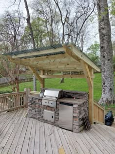 an outdoor bbq grill on a wooden deck