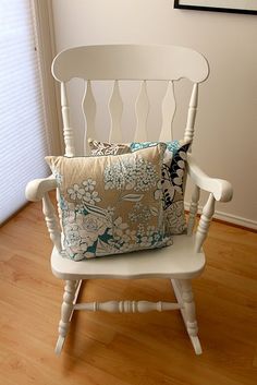 a white rocking chair with a pillow on it