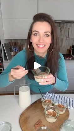 a woman sitting at a table with bowls of food and milk in front of her