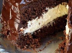 a close up of a cake with chocolate frosting and one slice cut from it