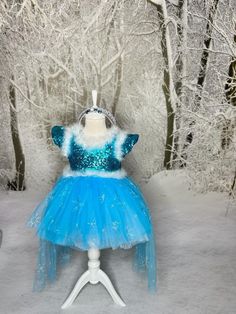 a blue and white dress sitting on top of a mannequin in the snow