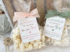 two bags filled with popcorn sitting on top of a table next to a necklace and other items