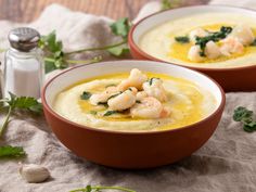 two bowls filled with soup and garnished with shrimp