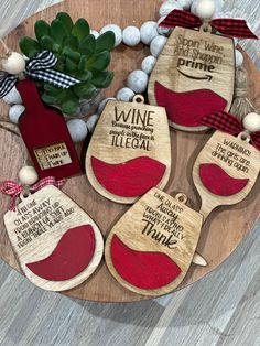 wooden wine tags with sayings on them sitting on a table next to a potted plant