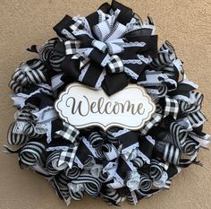 a welcome wreath with black and white bows