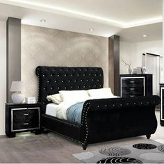 a black and white bedroom with an upholstered bed, nightstands and mirror