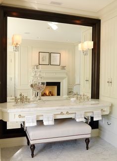 a white bathroom with a fireplace and vanity