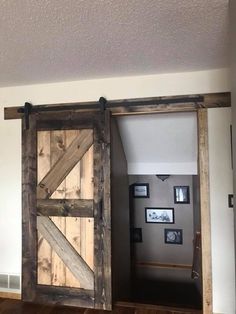 an open barn door in the corner of a room with wood floors and white walls