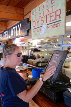 a woman standing in front of a counter with a laptop computer on it's side