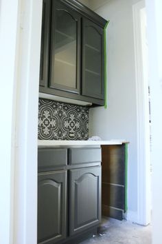 an empty kitchen with gray cabinets and green trim