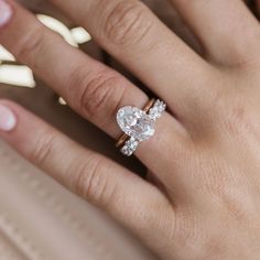 a woman's hand with a diamond ring on her finger and an engagement band