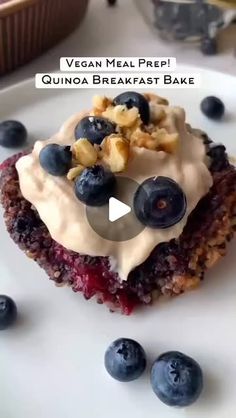 a white plate topped with blueberries and granola covered in cream cheese frosting