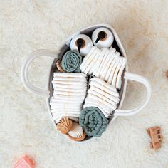 an owl made out of toilet paper and other items on a white carpet with toys around it